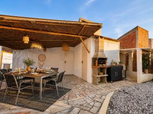 an outdoor patio with a table and a fireplace at Retiro São Pedro House in Aldeia da Mata