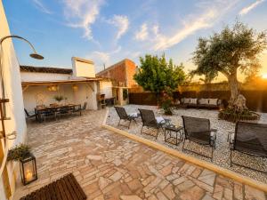 a patio with chairs and a table and a tree at Retiro São Pedro House in Aldeia da Mata