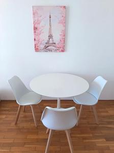 a white table and chairs with a picture of the eiffel tower at Riviera Budva Residence in Budva