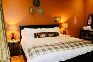 a bed in a bedroom with two tables and two lamps at The Kleemann House-1883 Historic Downtown Hotel in Custer