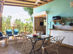 a kitchen and dining room with a table and chairs at Ti Colibri in Deshaies