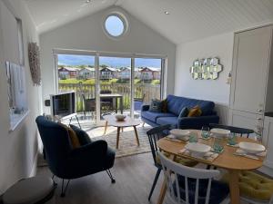 a living room with a table and a blue couch at The Lake House, The Bay Filey, sleeps 4 in 2 double rooms with ensuites, 1 dog welcome in Filey