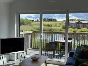 a living room with a flat screen tv on a deck at The Lake House, The Bay Filey, sleeps 4 in 2 double rooms with ensuites, 1 dog welcome in Filey
