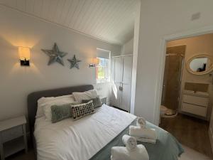 a bedroom with a bed with towels on it at The Lake House, The Bay Filey, sleeps 4 in 2 double rooms with ensuites, 1 dog welcome in Filey +28 photos