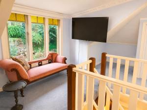 a living room with a chair and a staircase at Charnwood Cottages in Warburton