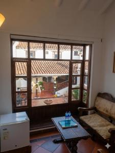 a living room with a large window and a table at Hotel Mesón de los Virreyes in Villa de Leyva