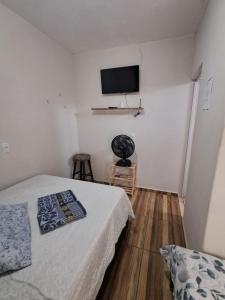 a bedroom with a bed and a flat screen tv at Suite Nomar 1 in Brotas