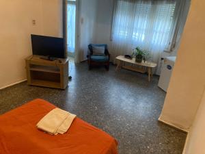 a room with a bed and a tv and a chair at Habitacion Privada, Single Room in Paysandú