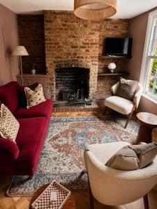 a living room with a red couch and a fireplace at St Johns Central Canterbury Cottage in Canterbury