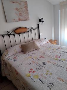 a bedroom with a bed with a floral blanket at Hostal Posada Royuela in Royuela