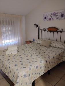 a bedroom with a bed with a floral bedspread at Hostal Posada Royuela in Royuela +8 photos