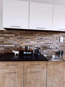 a kitchen with a black counter top and a sink at Apartman 053 in Doboj