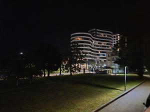 a tall building at night with a park in front of it at Riviera Budva Residence in Budva