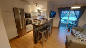 a kitchen with a counter and a bar with stools at DANAGUEST in Los Llanos de Aridane