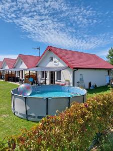 a house with a swimming pool in the yard at Domki letniskowe Reda in Rusinowo