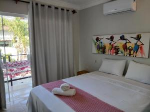 a bedroom with a bed with a towel on it at Pousada Caliandra Pipa in Pipa