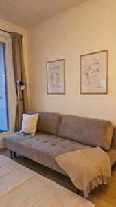 a living room with a brown couch in a room at Fabbrica's new and elegant apartment in Turku