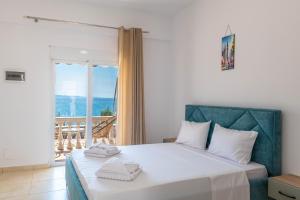 a bedroom with a large white bed with a balcony at The Hidden Sea Rooms in Sarandë