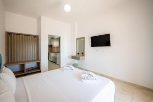 a white room with a bed and a tv at The Hidden Sea Rooms in Sarandë