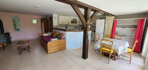a kitchen and a living room with a couch and a table at La maison de Fée-Licité in Salignac Eyvigues