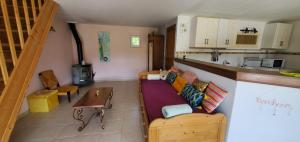 a living room with a couch and a kitchen at La maison de Fée-Licité in Salignac Eyvigues
