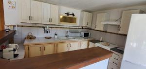 a kitchen with white cabinets and a sink at La maison de Fée-Licité in Salignac Eyvigues