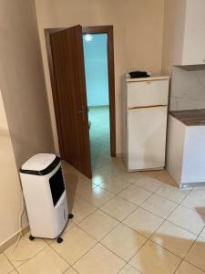 a room with a kitchen with a refrigerator and a door at Olive in Tirana