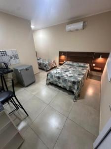 a room with two beds and a table in it at Hotel Don Luis in Paso de los Libres