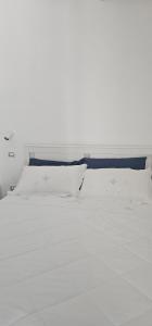 an empty white bed with white sheets and pillows at B&B Le Fontane in Bono