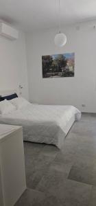 a white bedroom with a bed and a painting on the wall at B&B Le Fontane in Bono +18 photos