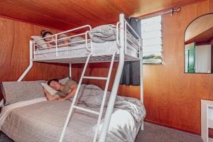 two people laying on a bunk bed in a room at Black Label Retreats in Gisborne