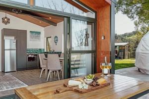 an open kitchen and dining area with a table with wine glasses at Black Label Retreats in Gisborne