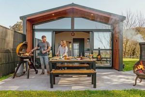 a man and a woman standing in front of aaria at Black Label Retreats in Gisborne +11 photos