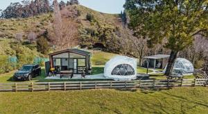 a couple of tents in a field with a car at Black Label Retreats in Gisborne