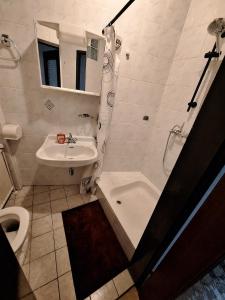a bathroom with a sink and a tub and a toilet at Pension Haus Marianne in Bad Vöslau