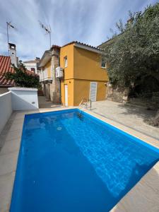 a blue swimming pool in front of a house at Casa da Prima in Torre de Moncorvo +3 photos