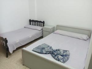 a bedroom with two beds and a hat on a table at لؤلؤه الفيروز in Marsa Matruh