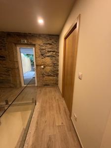 a room with a hallway with a door and a stone wall at Casa da Prima in Torre de Moncorvo