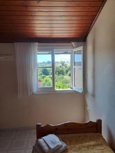 a bedroom with a bed and a window at Retire Alefkimmon in Lefkimmi