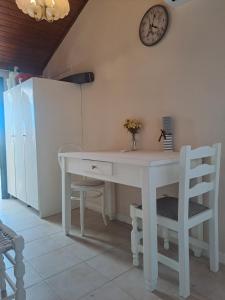 a white desk with a clock on the wall at Retire Alefkimmon in Lefkimmi +18 photos