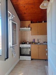 a small kitchen with a stove and a window at Retire Alefkimmon in Lefkimmi