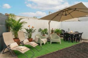 a patio with a table and chairs and an umbrella at Cocon du Souffleur in Port-Louis