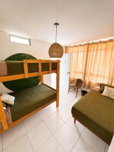 a bedroom with two bunk beds and a couch at Hostel Killamoon Centro in Paracas +50 photos