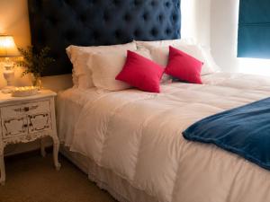 a white bed with two red pillows on it at Apartamento Castilla in Viña del Mar +33 photos