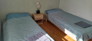 two twin beds in a room with a night stand at Eina house near the E4 road in Eina