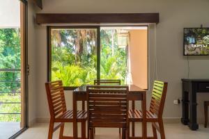 a dining room with a table and chairs and a window at Buena Vista Plus in Quepos