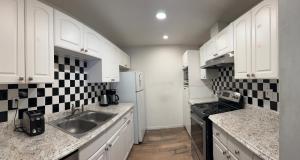 a kitchen with white cabinets and black and white tiles at BM master suite in Mountain View in Mountain View