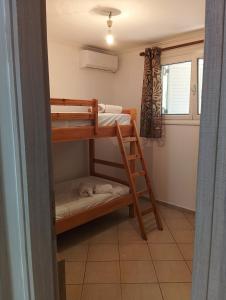 ein Zimmer mit zwei Etagenbetten und einem Fenster in der Unterkunft Amygdalos Room in Kómi