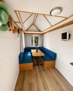a room with a table and blue seats in a trailer at No 7 Plasmolen in Middelaar