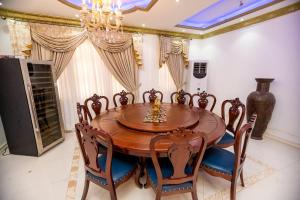 a dining room with a wooden table and chairs at XTENDED STAY Gh in Accra